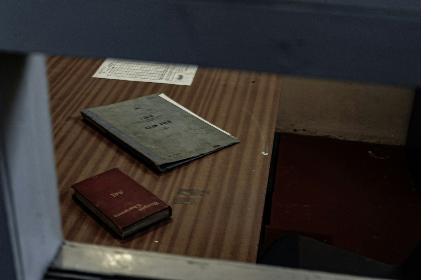 Fascicolo cartaceo e passaporto rosso su una scrivania in legno
